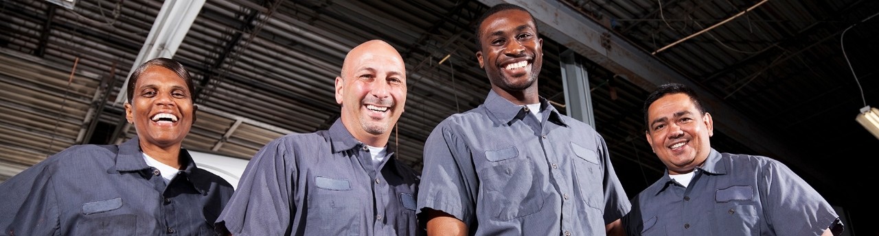 Multi-ehnic workers in service garage at trucking company.